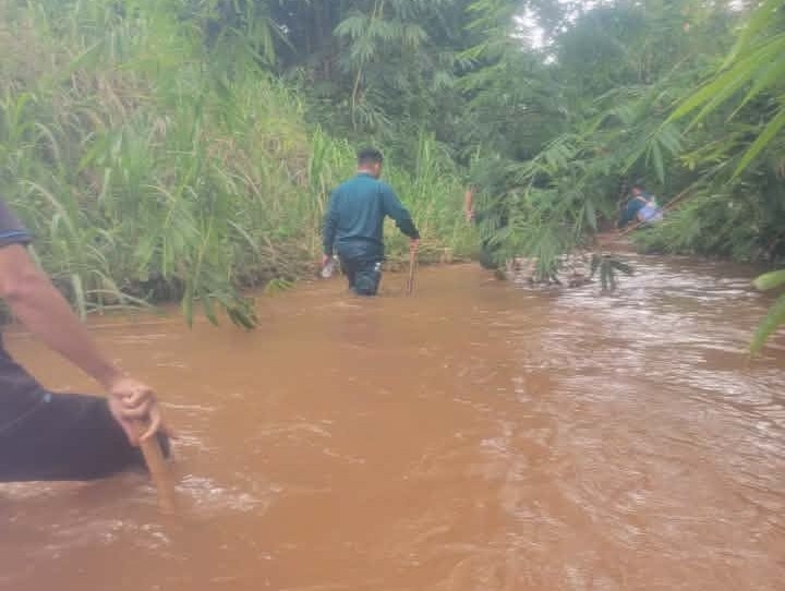 Lực lượng chức năng xã Đăk Ơ tìm kiếm con vật nghi là cá sấu xuất hiện ở dưới suối. Ảnh: Công an xã Đăk Ơ