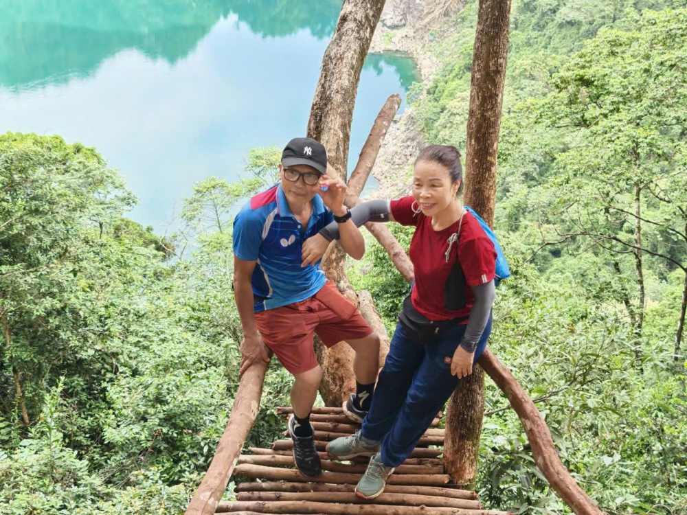 Mr. and Mrs. Binh take souvenir photos at Mat Ngoc Lake. Photo: Character provided