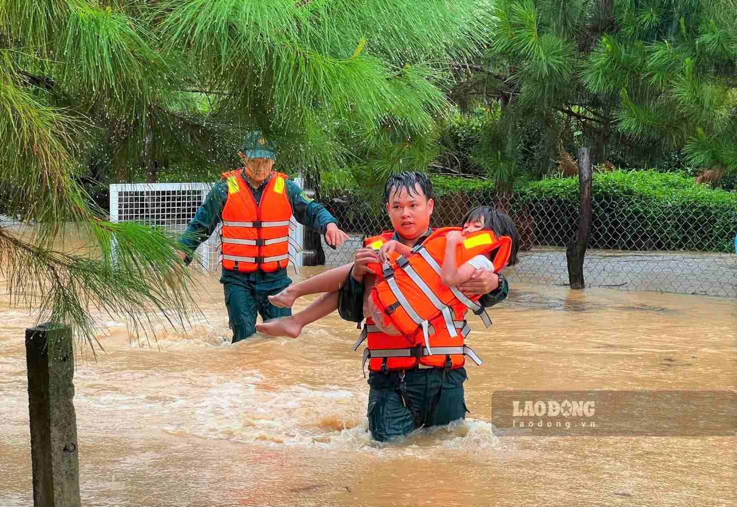 Militia forces brave the rain to overcome floods and relocate isolated people to safe places. Photo: Phuc Khanh