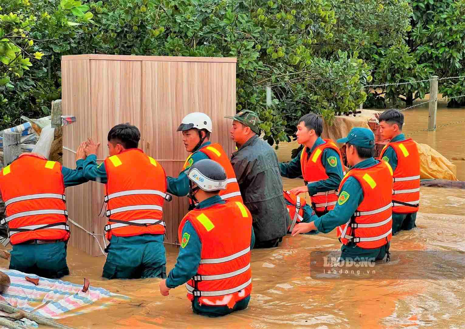 Các lực lượng phối hợp di chuyển tài sản của người dân bị ngập sâu đến nơi an toàn. Ảnh: Phúc Khánh 