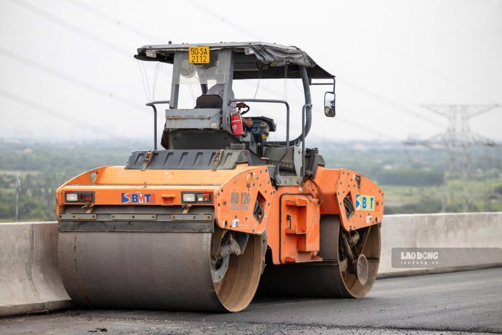 Các công nhân đang bắt đầu thảm nhựa mặt cầu lắp đặt hệ thống điện chiếu sáng và lan can.