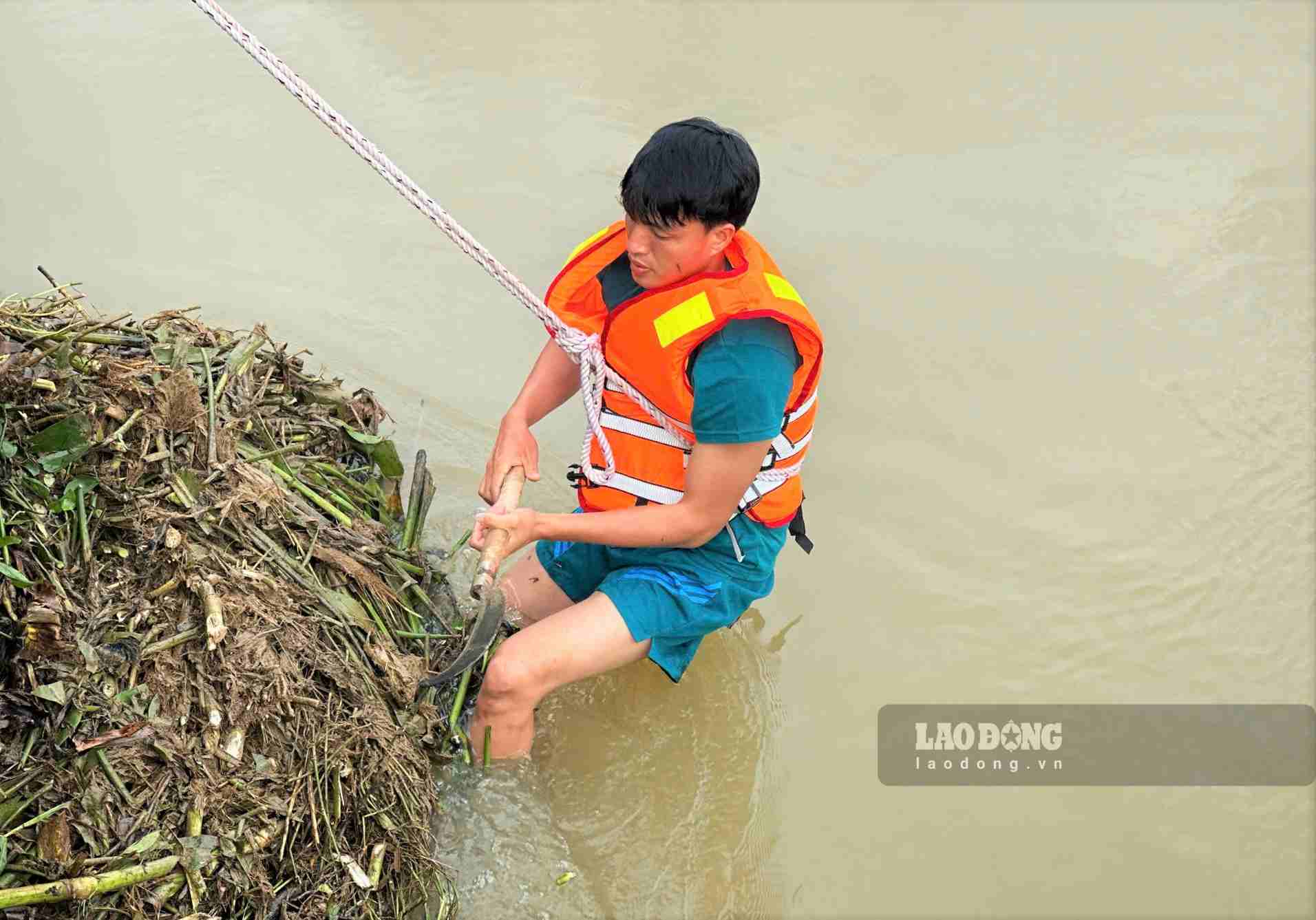 Chiến sĩ dân quân đu dây khơi thông dòng suối chống ngập tại phường 3 Bảo Lộc. Ảnh: Phúc Khánh 
