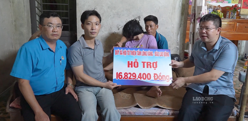 Representatives of the Golden Heart Charity Fund - Lao Dong Newspaper and local authorities presented more than 16.8 million VND to the family of Ngo Thi Anh Nguyet. Photo: Dinh Dai