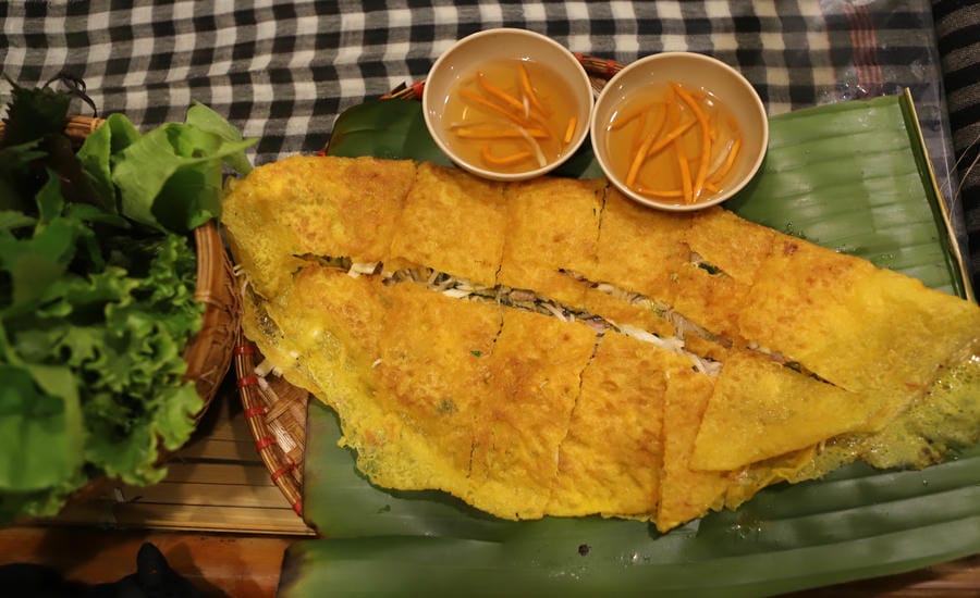 Bánh xèo được cắt thành từng miếng vừa ăn, dùng kèm rau sống và nước mắm chua ngọt theo phong cách miền Tây Nam Bộ. Ảnh: Minh Vũ