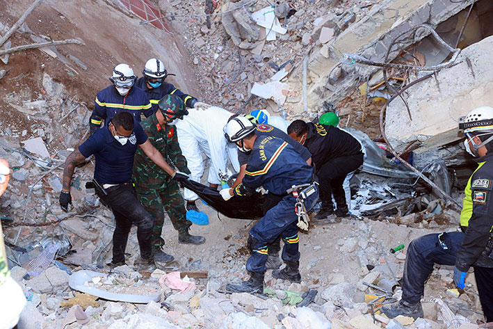 Vietnamese rescue forces remove the bodies of earthquake victims from the rubble. Photo: Khong Ha