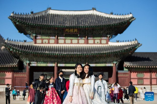 Du khách mặc trang phục Hanbok truyền thống chụp ảnh tại Cung điện Gyeongbokgung ở Seoul, Hàn Quốc. Ảnh minh họa: Xinhua