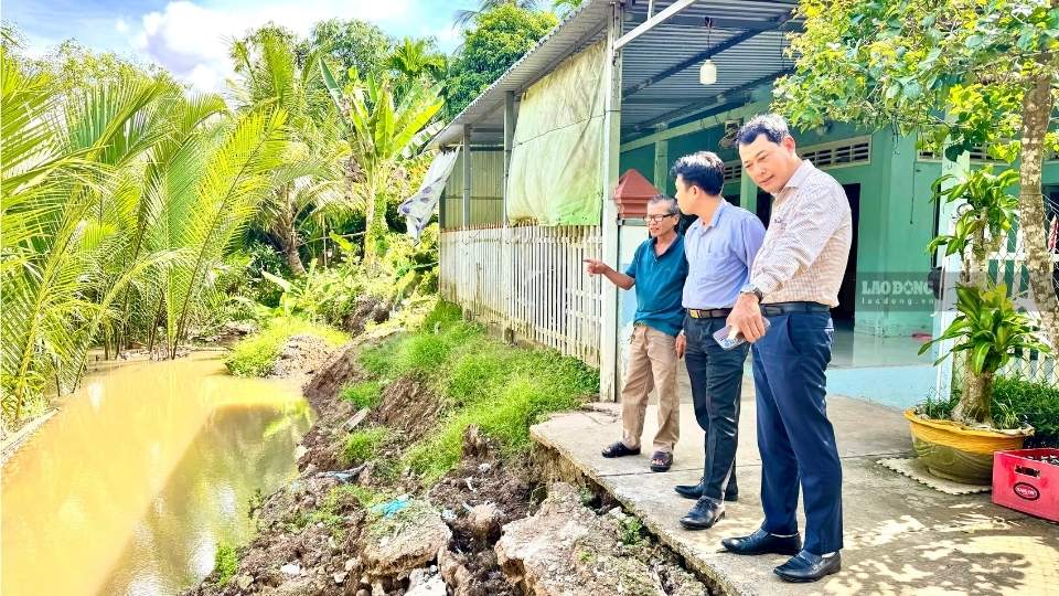 Mr. Tran Quang Tien (in blue t-shirt) is worried as the landslide point continues to spread, directly threatening his family's house. Photo: Hoang Loc