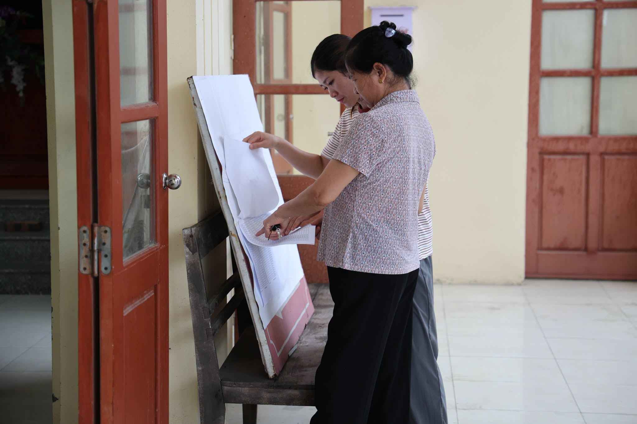 Người dân thôn Chằm tìm hiểu thông tin về công tác giải phóng mặt bằng dự án đường sắt tại bảng tin Ảnh: Xã Gia Lộc