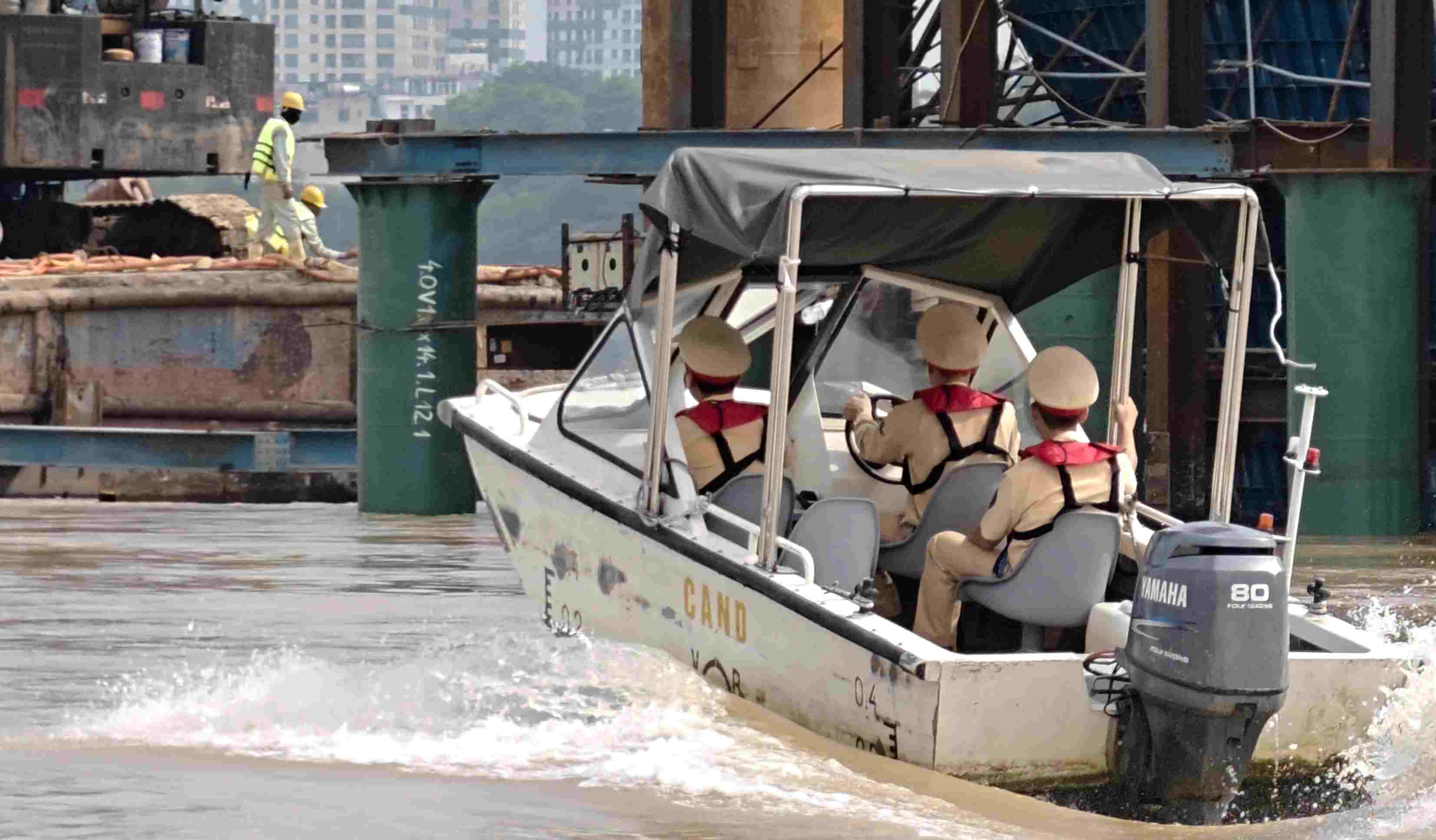 Hanoi traffic police go by canoe to inspect bridge construction sites on the Red River