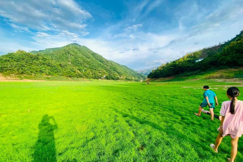 ソンラ省タコアコミューンのダ川沿いの緑の芝生は、乾季にチェックインに来る観光客を魅了しています。写真:タコアコミューン