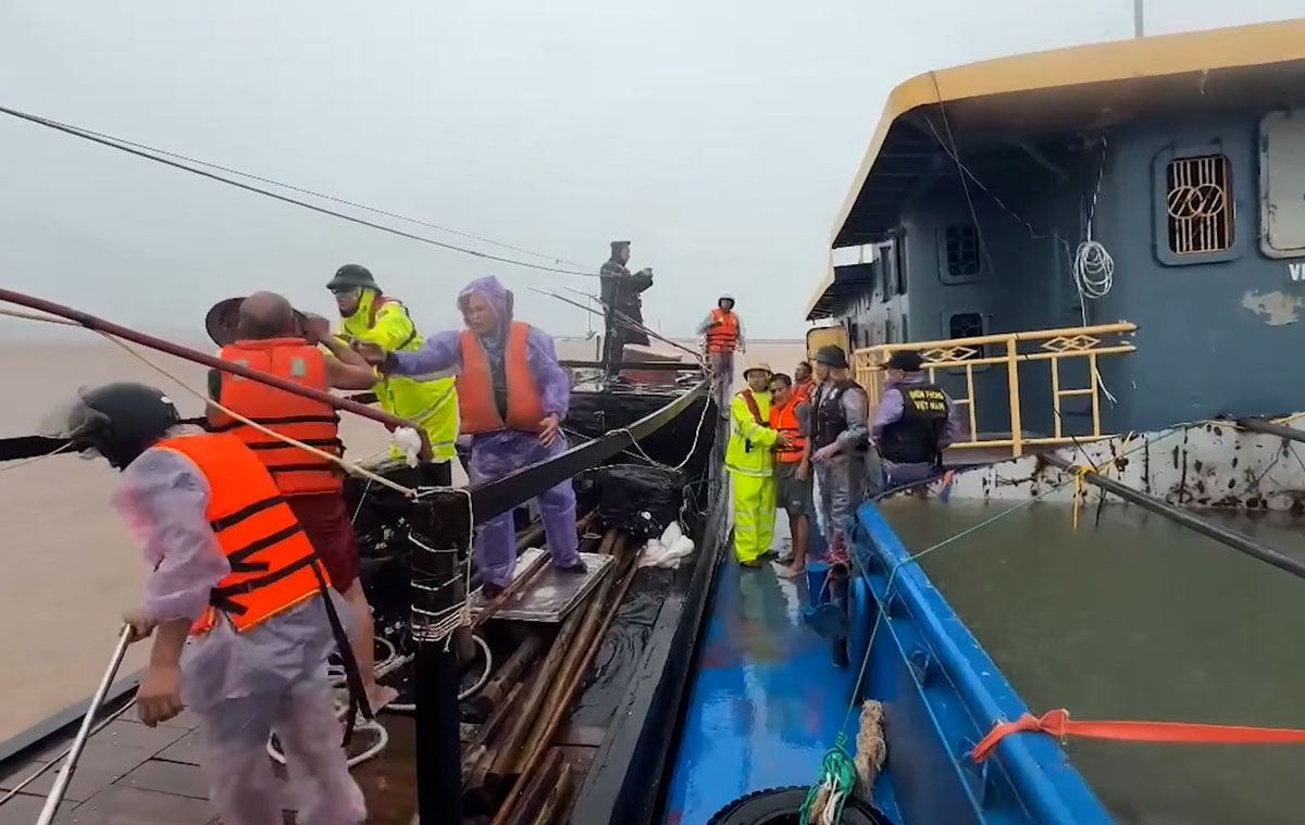 Rescue forces approach the distressed ship to bring the crew members ashore safely. Photo: Quang Ninh Police
