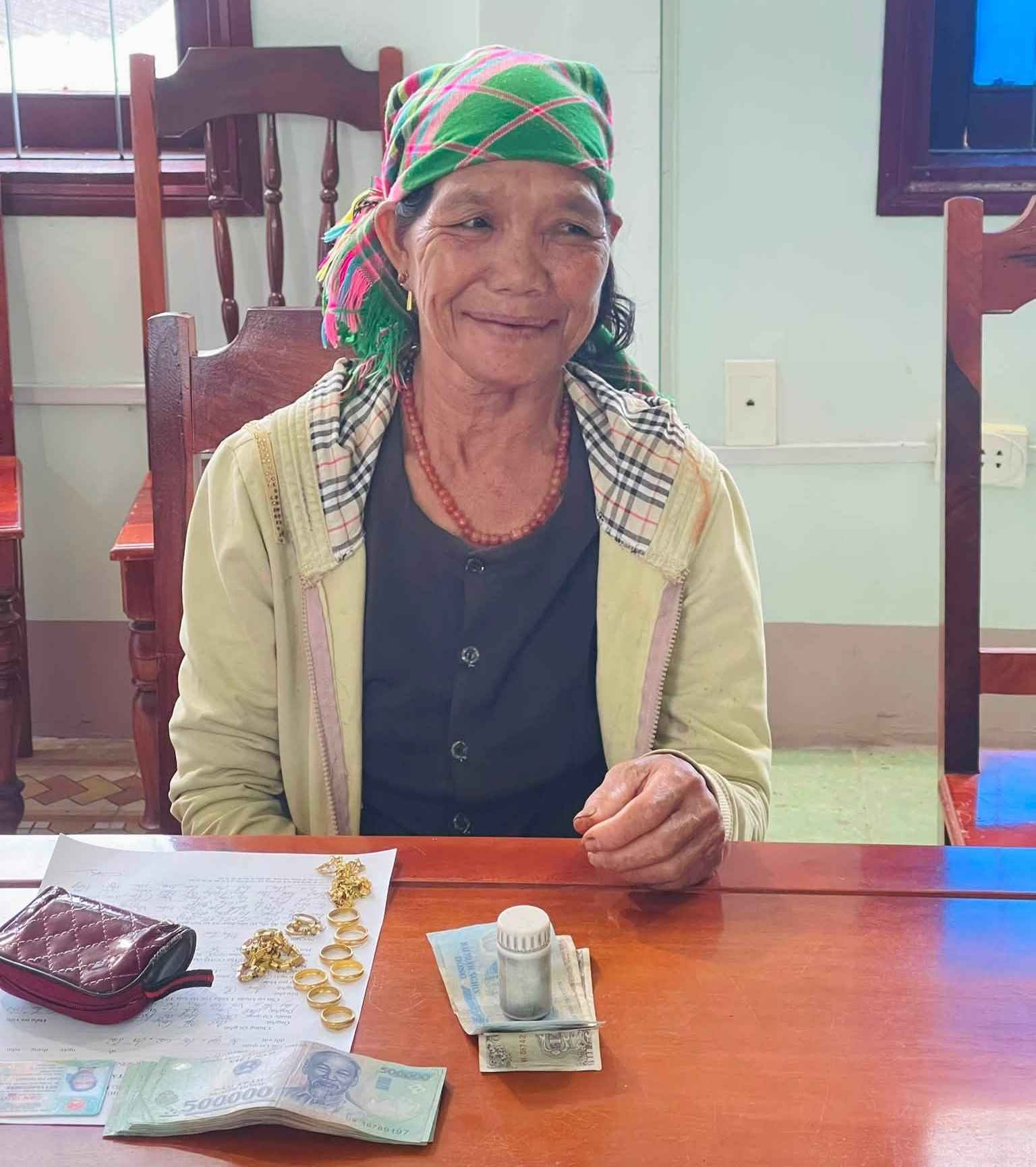 Bà Đinh Thị Hoách vui mừng khi nhận lại toàn bộ tài sản bị đánh rơi. Ảnh: Công an xã Sơn Hà