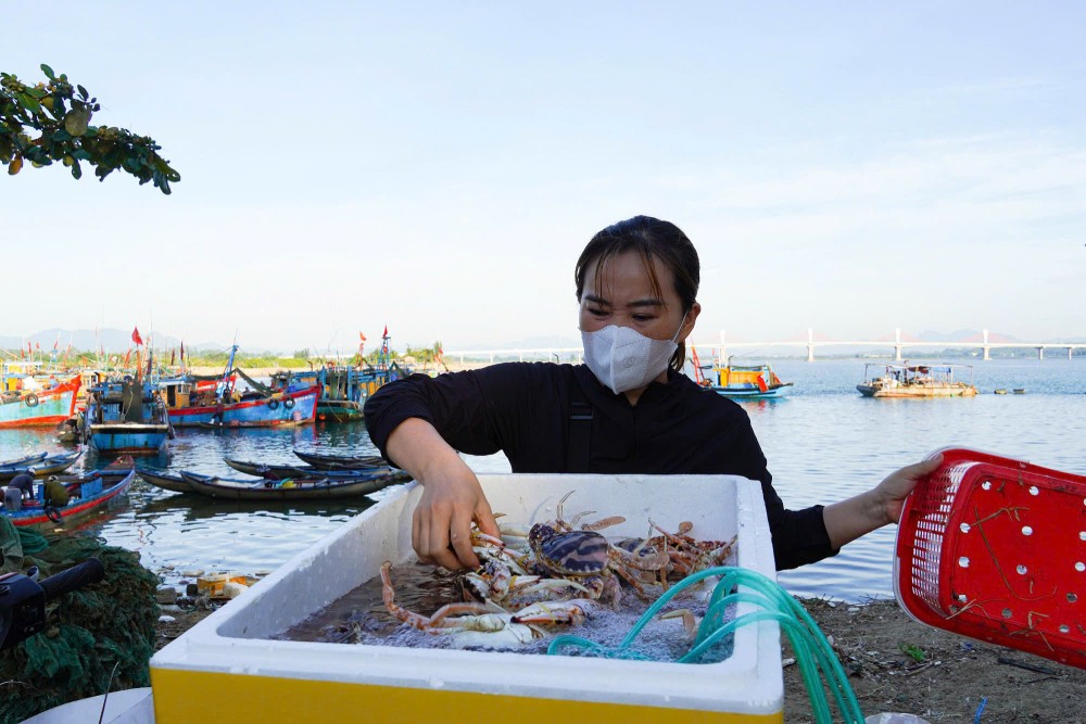 Chị em, phụ nữ tất bật đưa hải sản lên bờ để bán. Ảnh: Đông Giang
