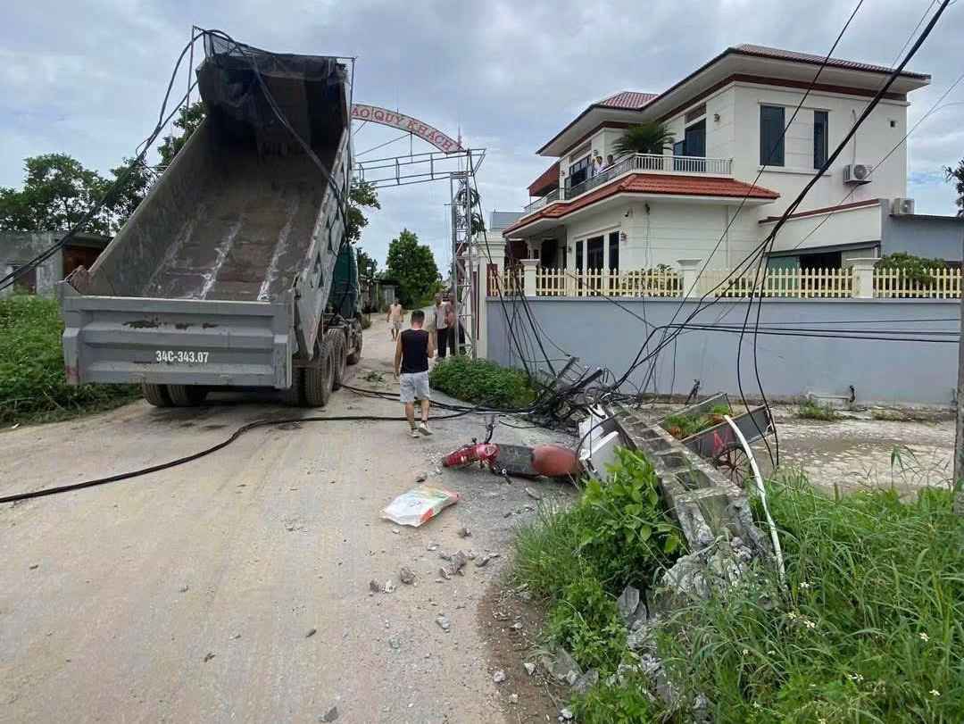 Scene of a truck crashing into an electric pole, leaning welcome gate in Khuc Thua Du commune, Hai Phong city. Photo: People provided