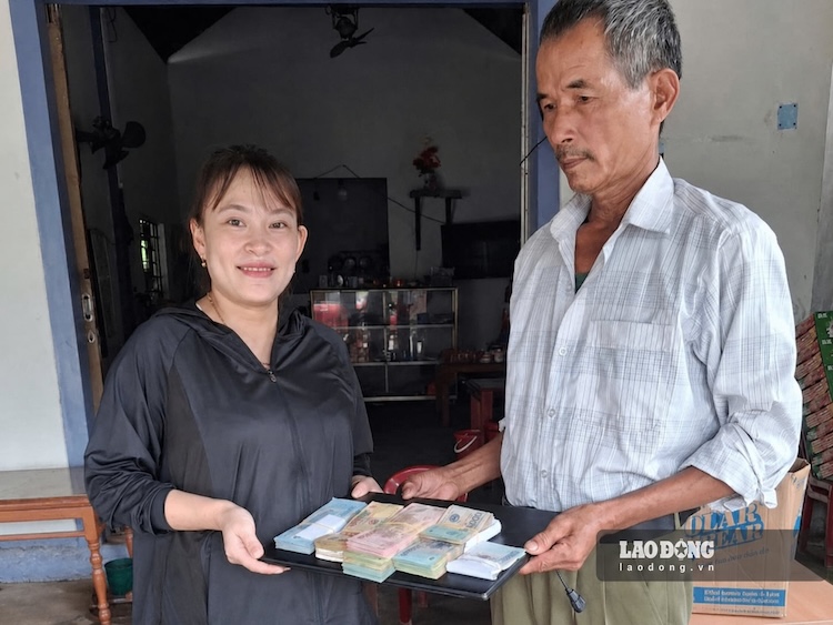 Ms. Huyen receives back the money and the computer from Mr. Bien's hand. Photo: T.Luyen
