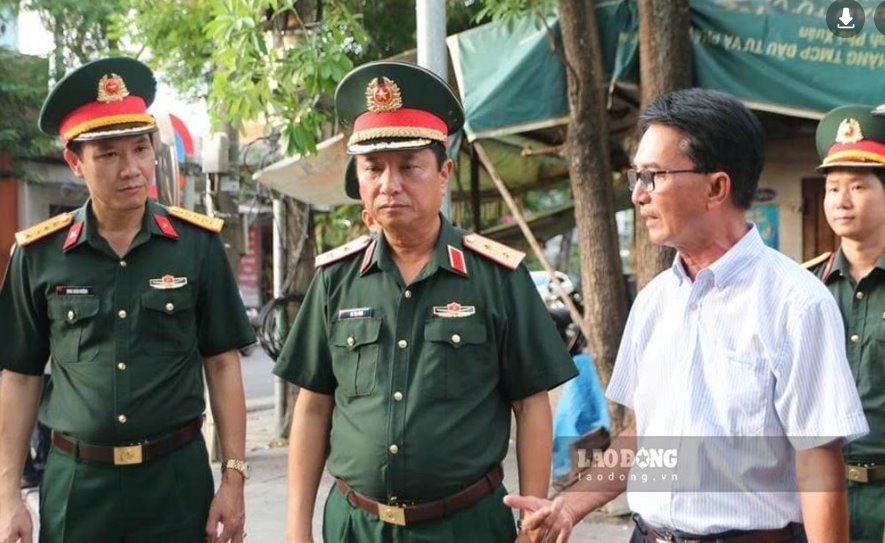 Mr. Le Van Luot (white shirt) talks with Lieutenant General Ha Tho Binh - Commander of Military Region 4 (middle) - at the search for collective martyrs' graves in Hue Citadel. Photo: Nguyen Luan