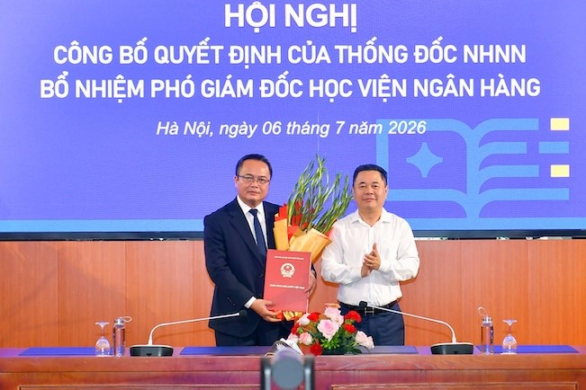 Phó Thống đốc Ngân hàng Nhà nước Nguyễn Ngọc Cảnh tặng hoa và trao Quyết định cho tân Phó Giám đốc Học viện Ngân hàng Lê Ngọc Thắng. Ảnh: Học viện ngân hàng