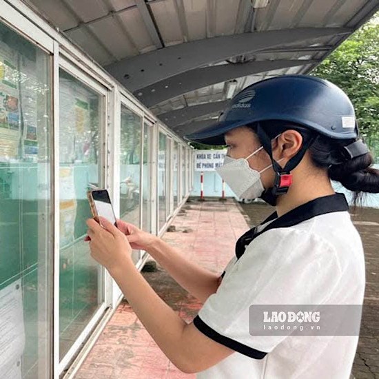 Chị Nguyễn Thị Trang tìm hiểu việc làm tại Bảng thông báo tuyển dụng gần Khu công nghiệp Thăng Long. Ảnh: Minh Hương.