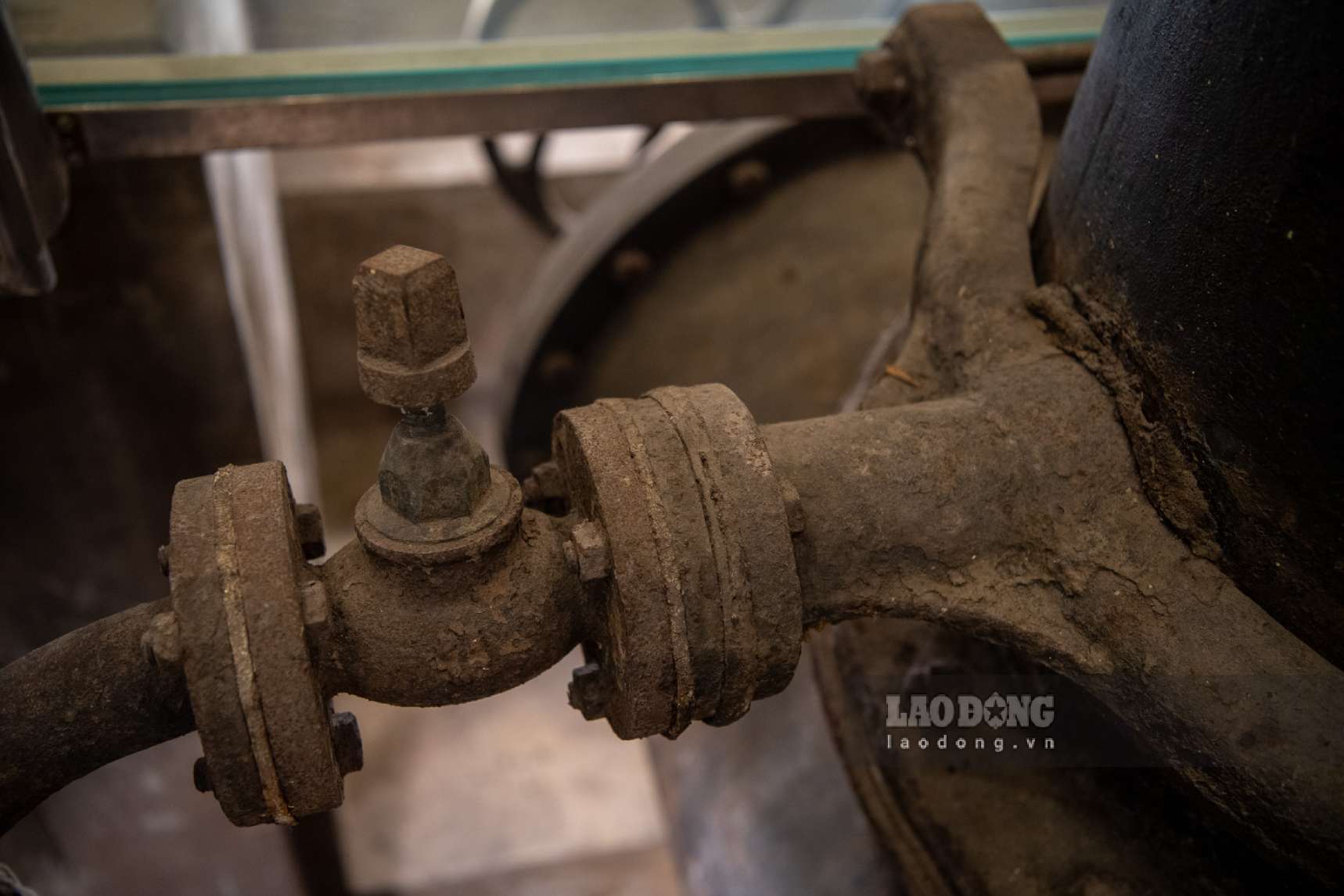 Hệ thống ống dẫn nước bằng sắt, thép từ bồn chứa xuống tầng trệt vẫn được bảo tồn nguyên vẹn. Khu vực nền được lắp kính chịu lực để phục vụ khách tham quan quan sát kết cấu bên dưới. Ảnh: Thái Bảo.