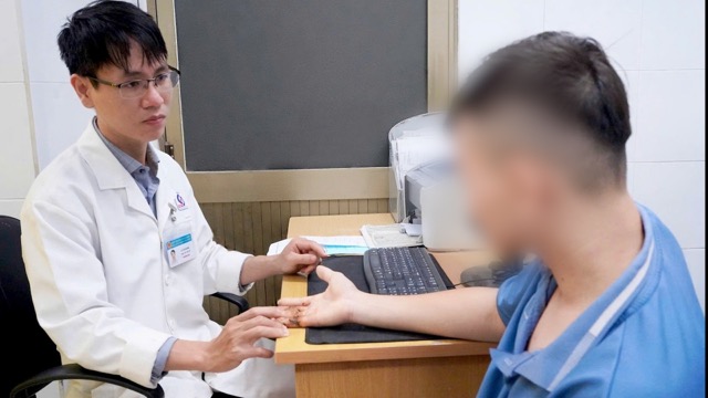 The patient was examined by doctors after successful surgery on a finger that was almost completely severed. Photo: Provided by Nhan Dan Gia Dinh Hospital