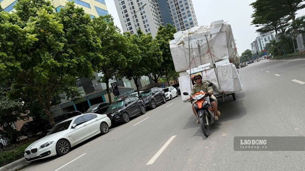 Xe máy tự chế kéo theo hàng hóa trên đường Dương Đình Nghệ. Ảnh: Minh Hạnh chụp 11h30 ngày 8.7.2026.