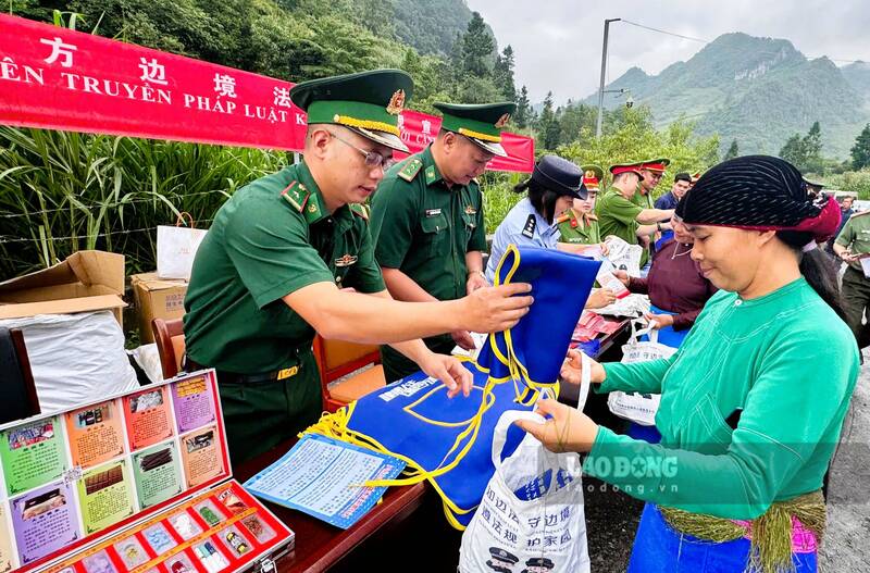 Cư dân hai bên biên giới được tặng các vật dụng có in nội dung phổ biến pháp luật. Ảnh: Thái An