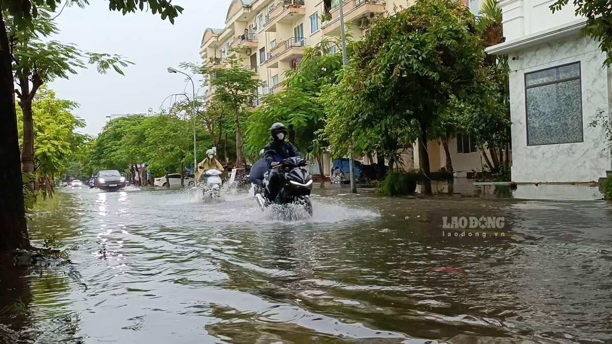 Đường Nguyễn Tất Tố cũng ngập sâu, có đoạn ngập ngang bánh xe máy khiến người dân khó khăn trong việc di chuyển. Ảnh: Mai Dung