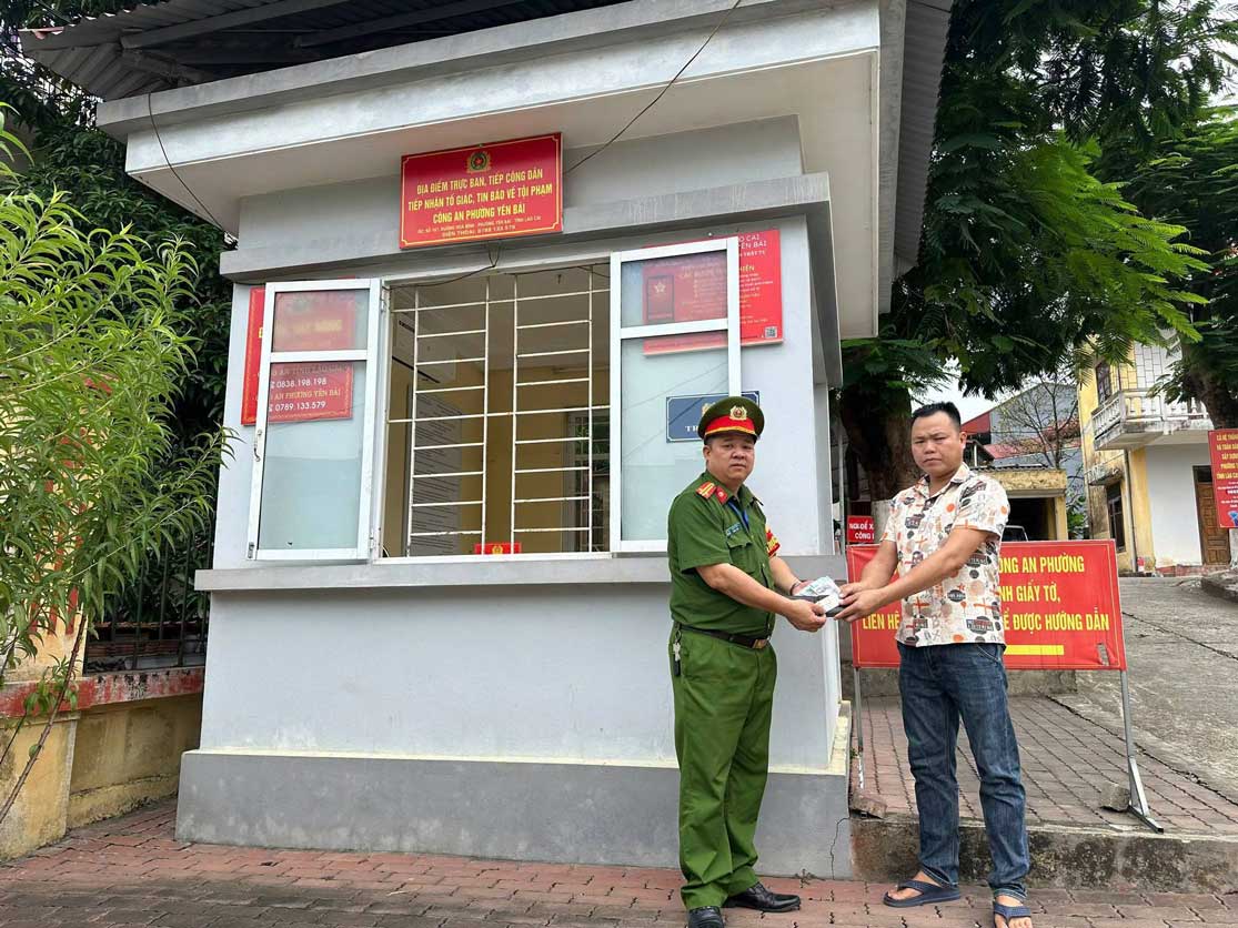 Anh Trần Minh Tuấn giao nộp tài sản nhặt được để trả người đánh rơi. Ảnh: Công an phường Yên Bái