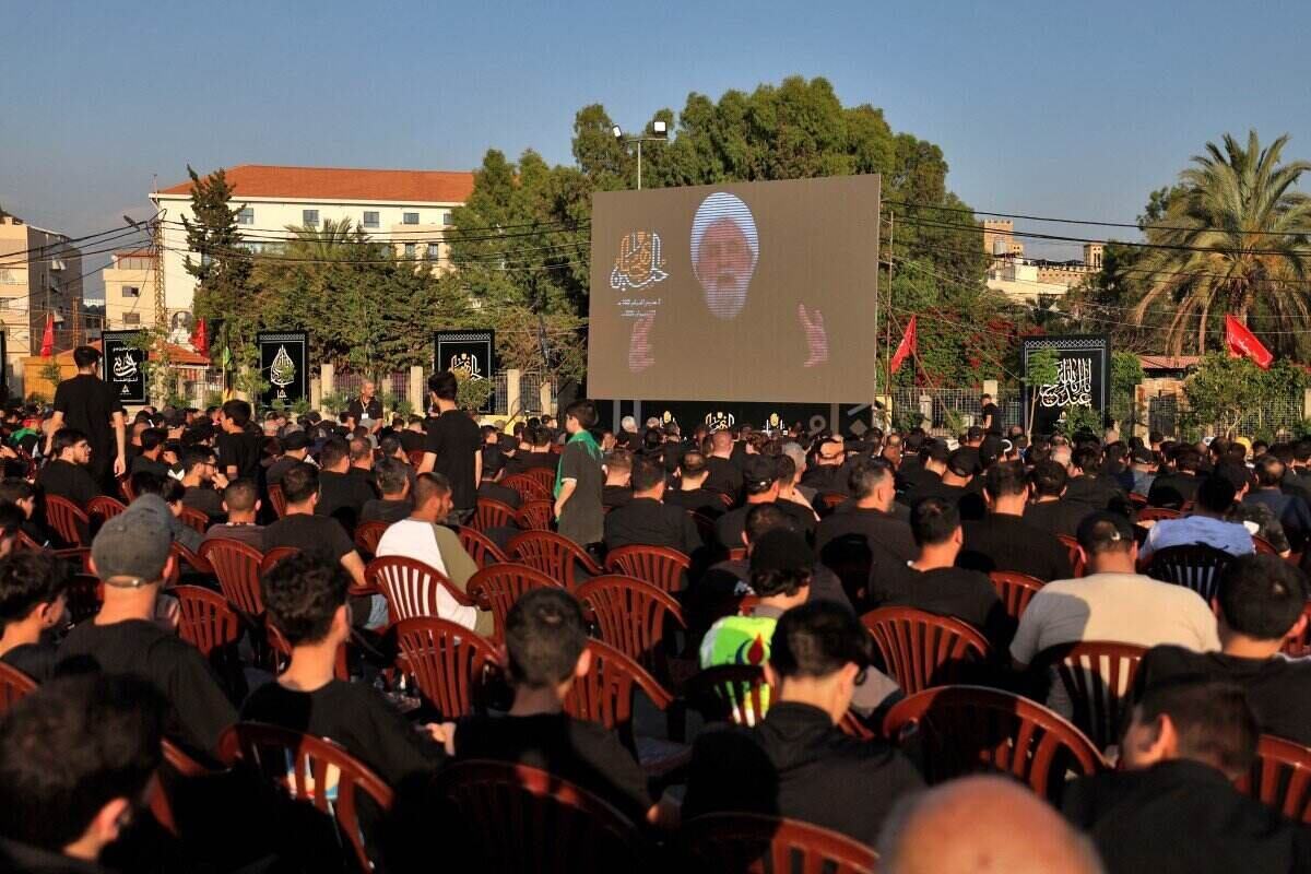Hezbollah Secretary General, Sheikh Naim Qassem, speaks to the crowd through a giant screen. Photo: AFP