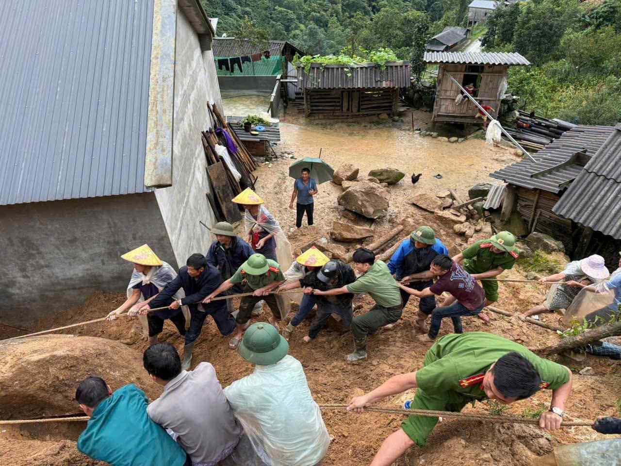 Lực lượng công an cùng người dân địa phương xử lý viên đá có nguy cơ sạt lở. Ảnh: Công an Lai Châu