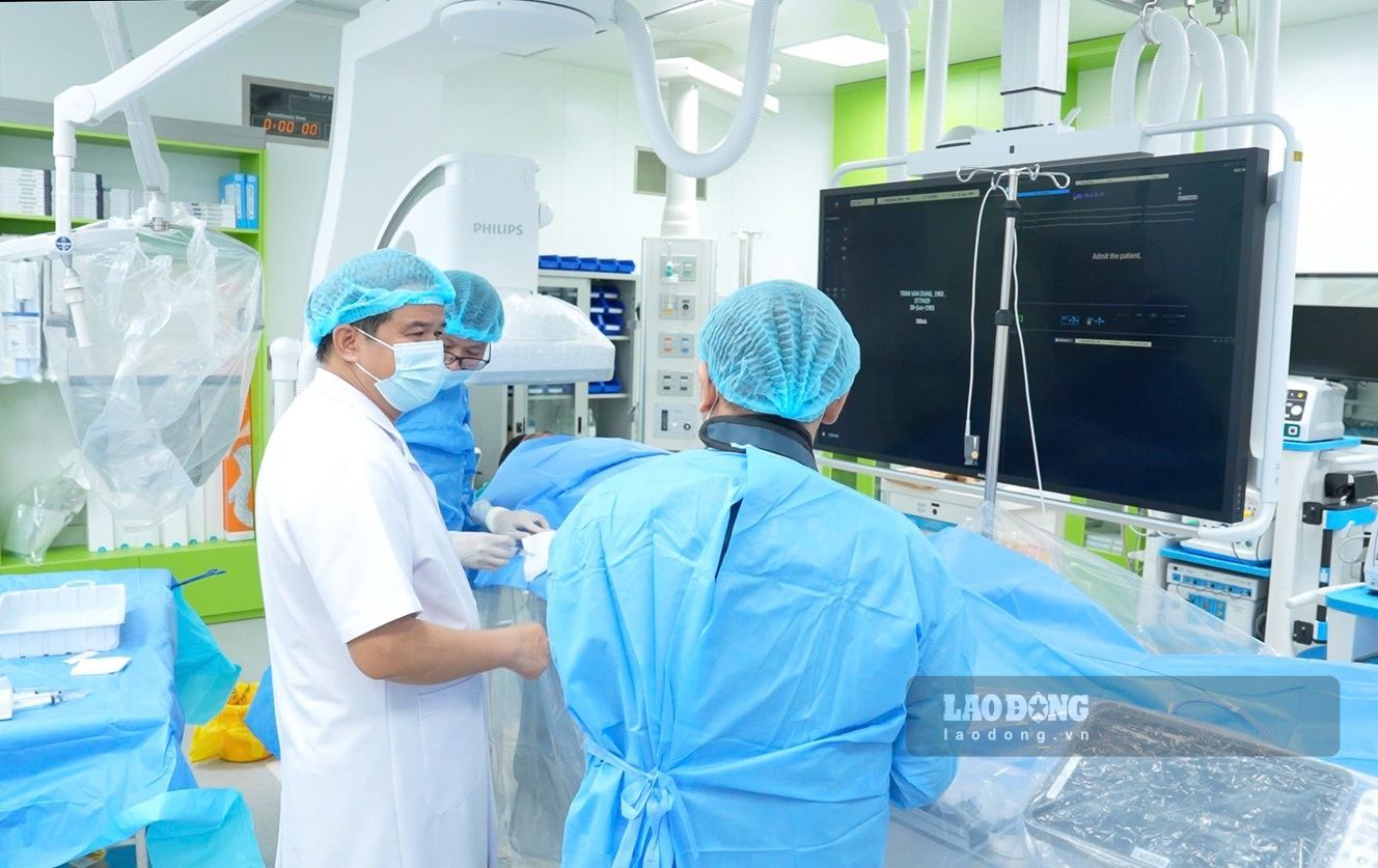 Le professeur associé et docteur Dao Xuan Co - directeur de l'hôpital Bach Mai est présent dans la salle d'intervention pour diriger les opérations d'urgence pour l'infarctus du myocarde. Photo: Thanh Duong