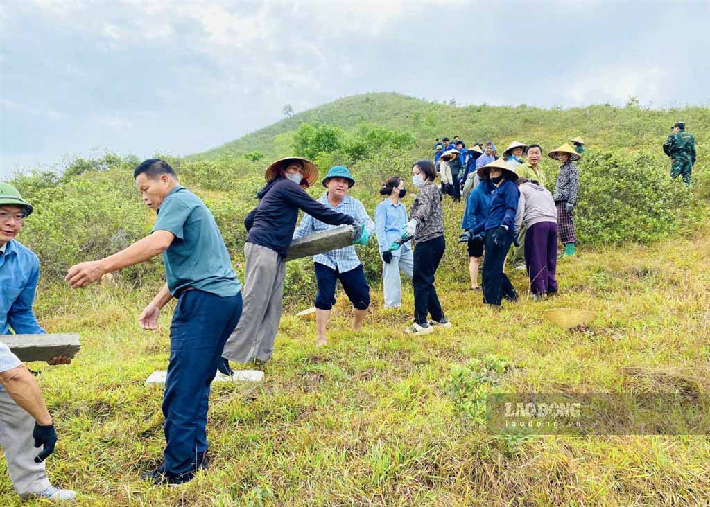 Hàng trăm cán bộ, đoàn viên và người dân xã Lam Thành tạo thành dây chuyền, chuyền tay nhau từng tấm bê tông lên Núi Nhón. Ảnh: Duy Chương