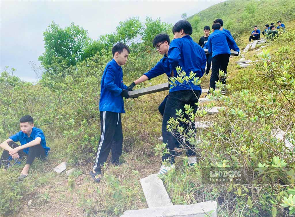 Đoàn viên thanh niên vận chuyển các tấm bê tông trên sườn Núi Nhón để phục dựng dòng chữ có từ cuối năm 1969. Ảnh: Duy Chương