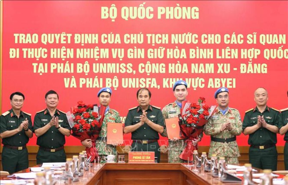 Trao quyết định của Chủ tịch nước cho các sĩ quan đi thực hiện nhiệm vụ gìn giữ hoà bình. Ảnh: TTXVN