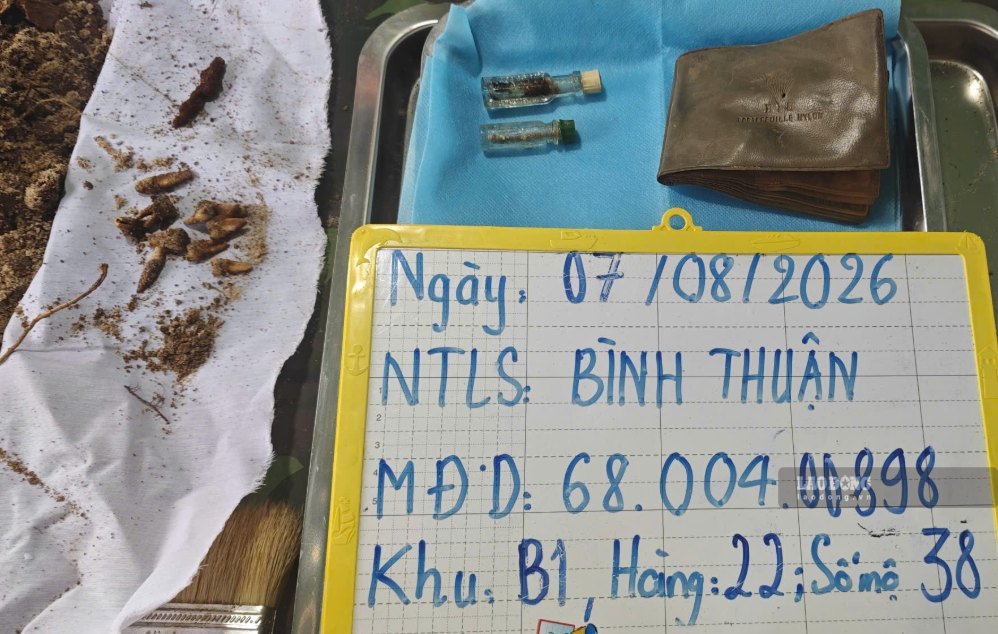 Lực lượng chức năng tìm thấy kỉ vật khi quật phần mộ ở Nghĩa trang liệt sĩ Bình Thuận. Ảnh: Duy Tuấn 