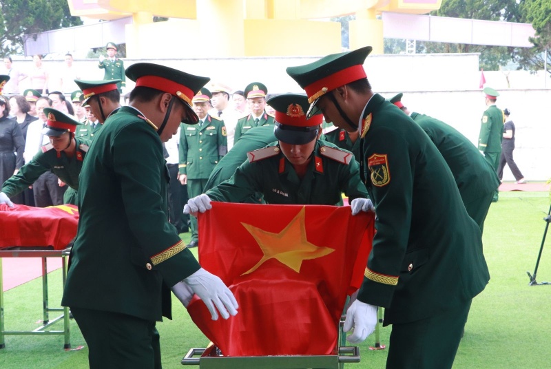Thực hiện nghi thức an táng liệt sĩ vào phần mộ tập thể. Ảnh: Laichau.gov.vn
