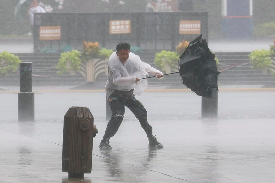 People move with difficulty amidst heavy rain and strong winds due to the impact of Typhoon Dolphin in Huangpu County, Shanghai, China, August 9, 2026. Photo: Xinhua