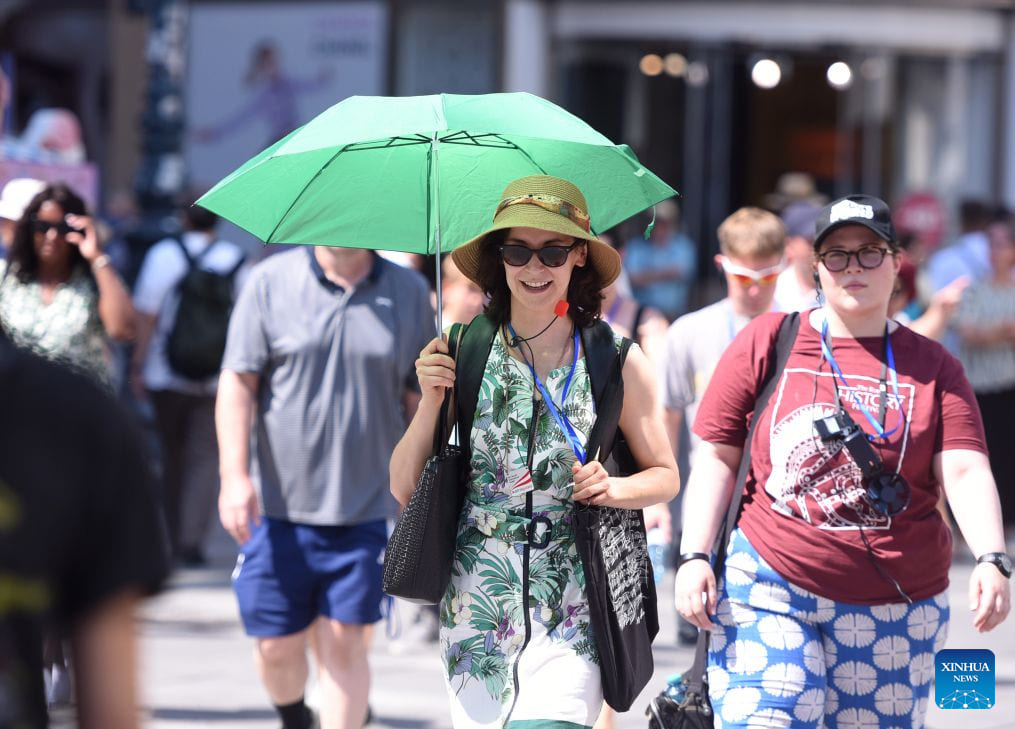 People walk on a street in Vienna, Austria, amidst record heat when temperatures in this country first reached 41 degrees Celsius. Photo: Xinhua