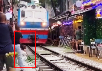 Girl sitting close to the train tracks. Screenshot. Source: Phuc Thinh