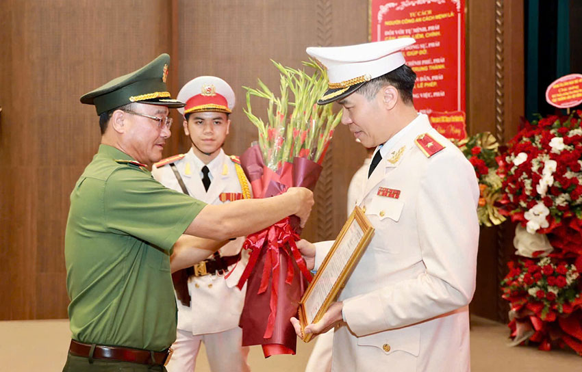 Deputy Minister of Public Security Pham The Tung presents the transfer decision to Major General Cao Minh Huyen. Photo: Immigration Department