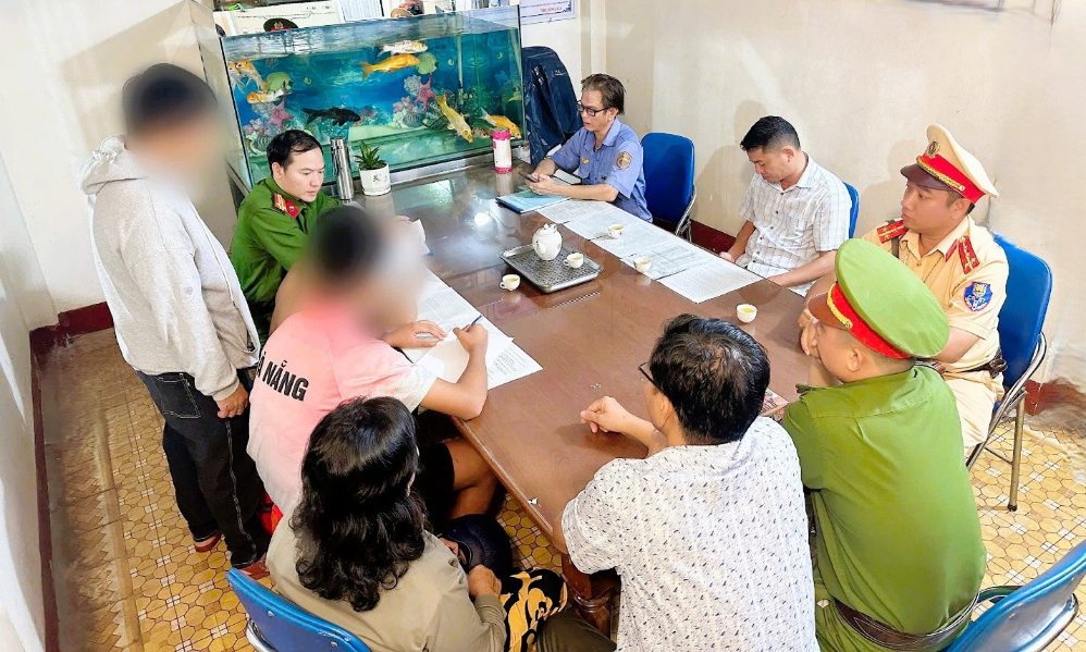 Hai em thiếu niên cùng phụ huynh ký cam kết không tái phạm sau khi được lực lượng chức năng nhắc nhở hành vi ném đá vào tàu hỏa. Ảnh: Công an TP Đồng Nai