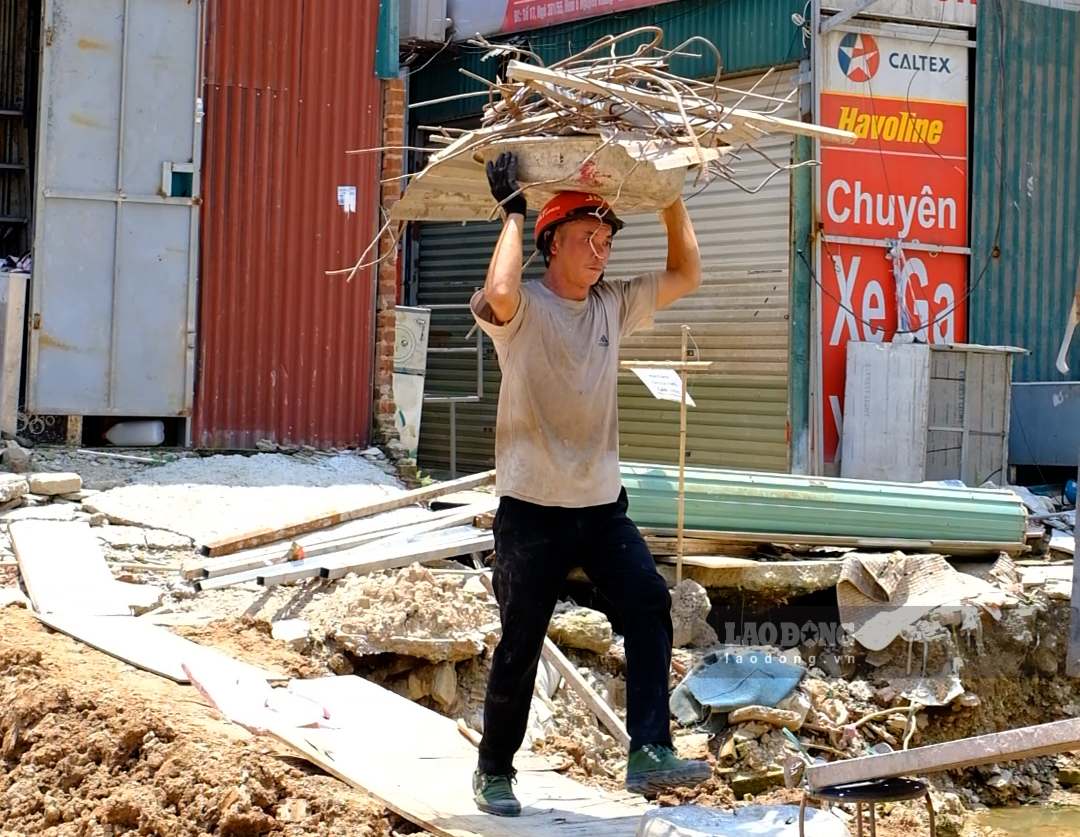 Người lao động đội những chậu sắt nặng trên đầu, tất bật bốc xếp phế liệu giữa thời tiết nắng nóng. Ảnh: Hạnh Thơm
