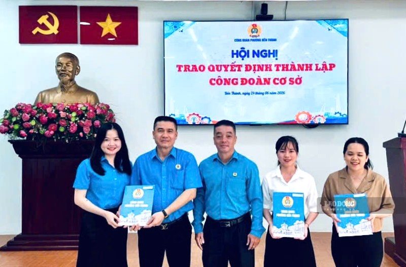 Mr. Huynh Vinh Lam - Chairman of Ben Thanh Ward Trade Union (standing in the middle) - presents the decision of the Ho Chi Minh City Labor Federation to establish a grassroots trade union. Photo: Duc Long