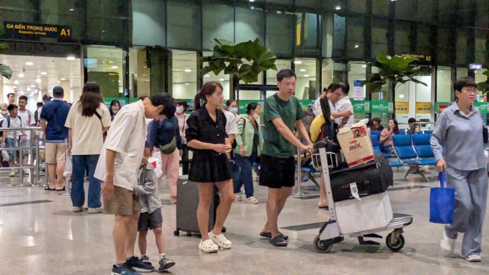 Khu vực ga đến T1 đông hành khách trong tối 11.8, sau khi hoạt động cất hạ cánh bị gián đoạn. Ảnh: Thái Bảo