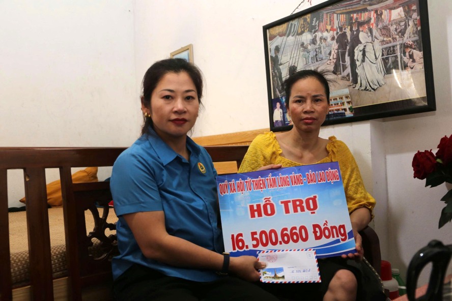 Trao 16,5 triệu đồng do bạn đọc ủng hộ thông qua Quỹ Xã hội từ thiện Tấm lòng Vàng - Báo Lao Động đến chị Lường Thị Tỉnh. Ảnh:  BẢO  NGUYÊN 