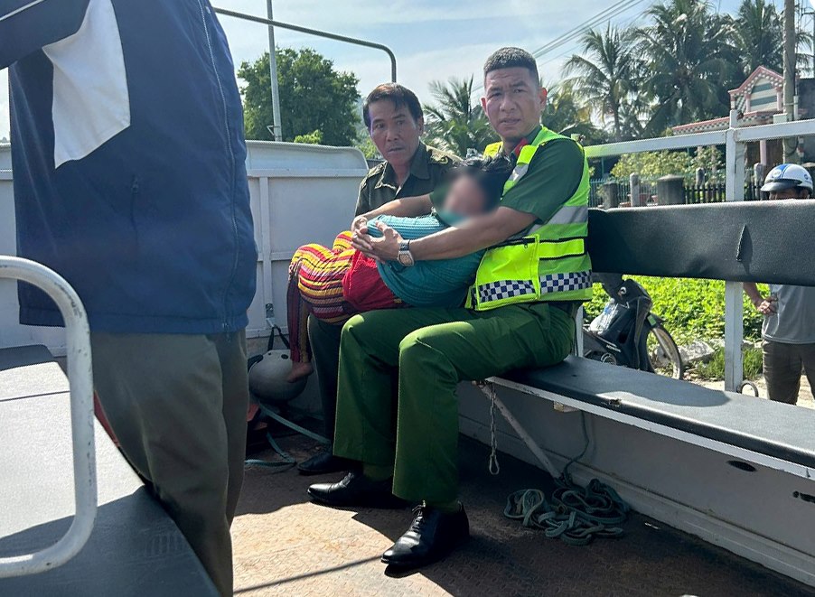 Commune police give first aid and take the woman who fainted by the roadside to a medical facility for emergency treatment. Photo: Police provided