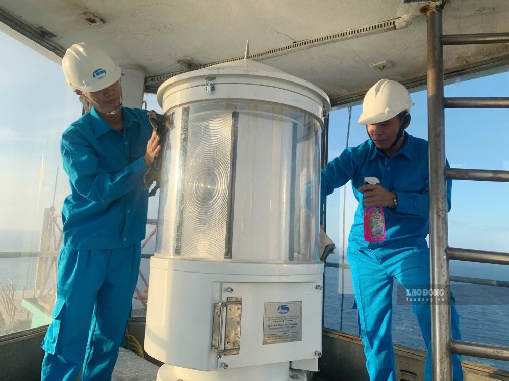 Những công nhân bảo dưỡng hệ thống đèn biển trên hải đăng. Ảnh: Duy Tuấn