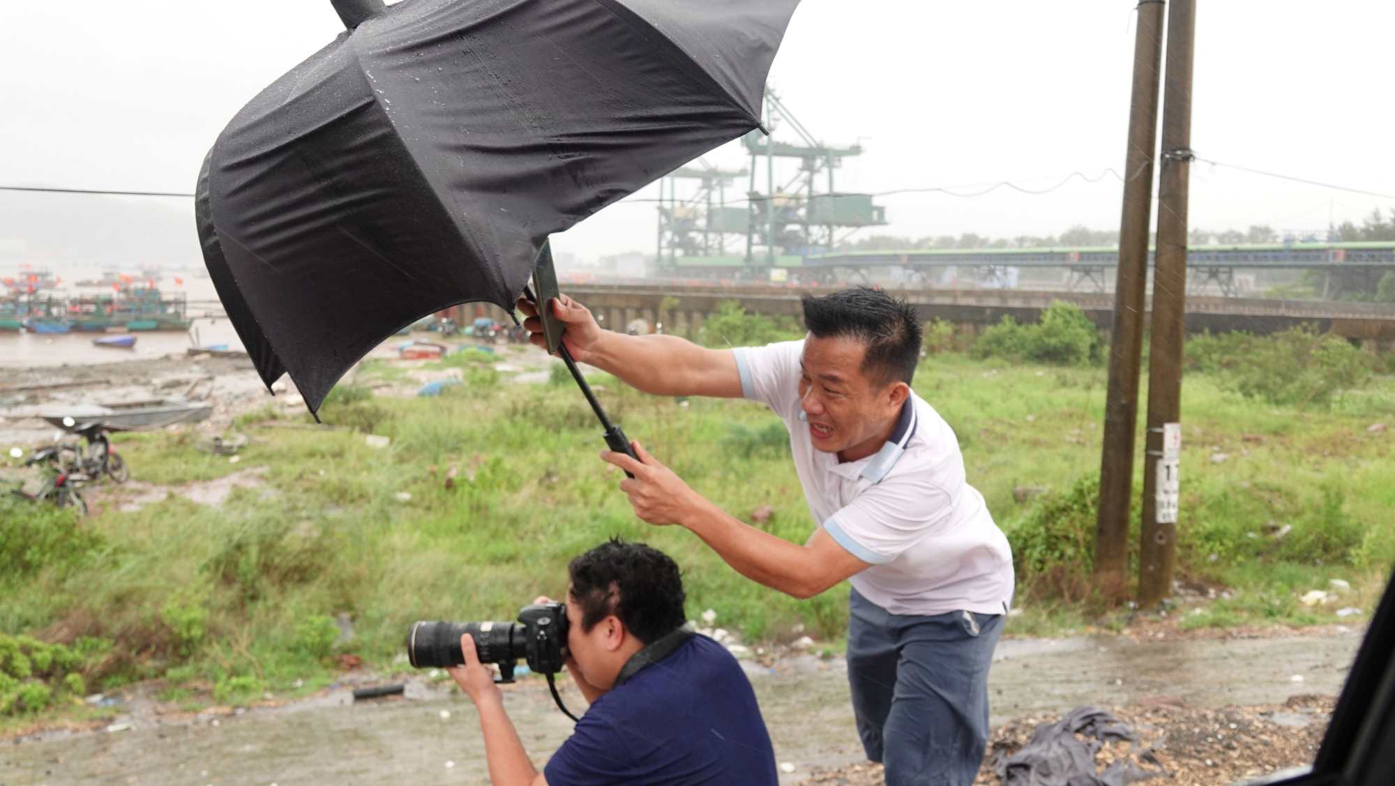 The author (wearing a white shirt holding an umbrella) works during storm No. 10 (year 2025) in the sea area of Nghi Son island commune, Thanh Hoa province. Photo: QUACH DU
