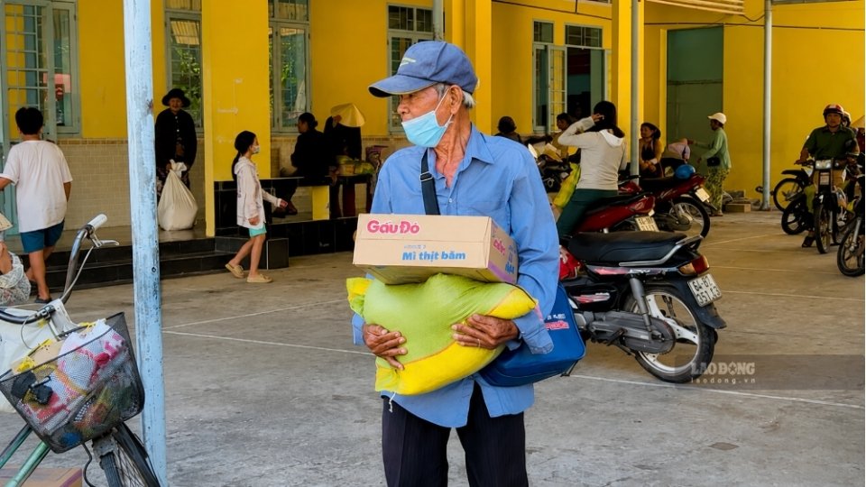 Người dân vui mừng nhận phần quà gồm gạo và mì do Ủy ban MTTQ Việt Nam phường Long Châu trao tặng. Ảnh: Hoàng Lộc