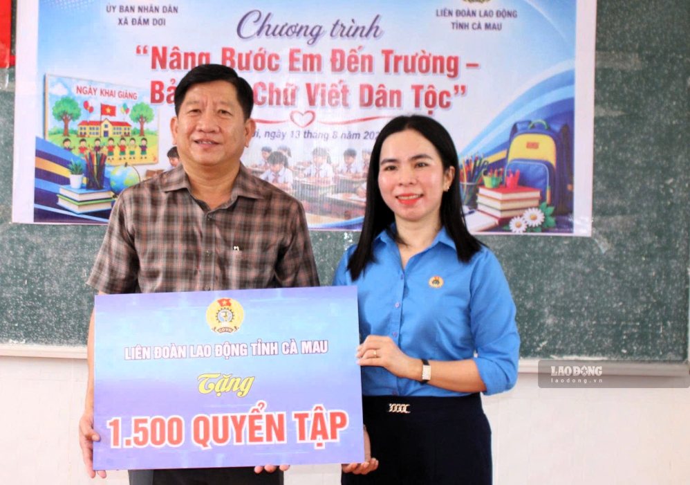 Ms. Ngo Diem Phuc - Standing Vice Chairwoman of Ca Mau Provincial Labor Federation - presents a symbolic plaque donating 1,500 notebooks to Chairman of Dam Doi Commune People's Committee Nguyen Tri Tai. Photo: Thieu Vu